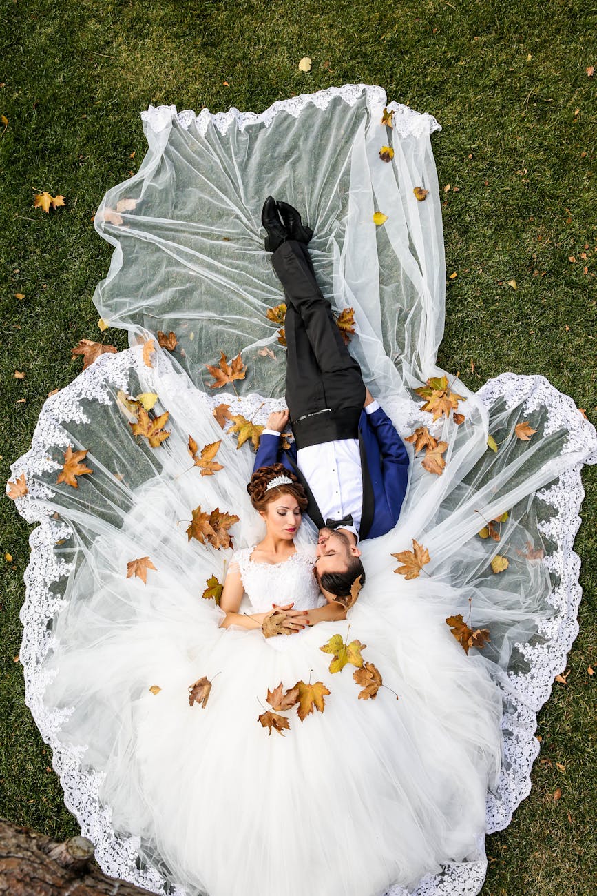 aerial photo of man and woman lying on grass field